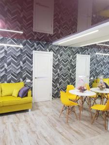 a dining room with yellow chairs and a yellow couch at Квартира Lux біля Саржиного Яру in Kharkiv