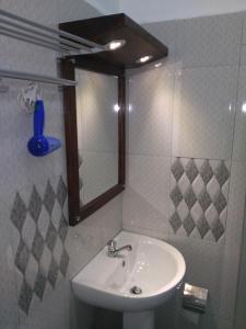 a bathroom with a sink and a mirror at Kandy Citylights Residence in Kandy