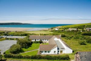 an aerial view of a house with the ocean in the background at YHA Broad Haven in Broad Haven