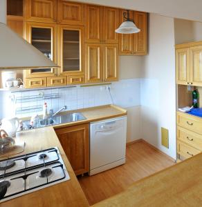 a kitchen with wooden cabinets and a stove top oven at Apartmán Belá in Spišská Belá