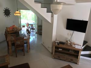 ein Wohnzimmer mit einem TV und einem Esszimmer in der Unterkunft Linda casa em condomínio in Paraty