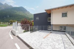 a building with a gate next to a building with mountains at Terrazze sul Garda in Tenno