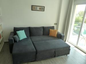 sala de estar con sofá y almohadas en Sunny Apartments, en Cala del Moral