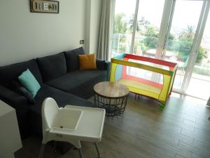 ラ・カラ・デル・モラルにあるSunny Apartmentsのリビングルーム(ソファ、テーブル付)