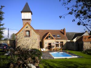 a large brick house with a tower and a swimming pool at Gite 3 épis Tour de Charme in Péruwelz