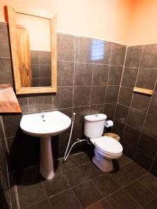 ein Badezimmer mit Toilette, Waschbecken und Spiegel in der Unterkunft House of Sanskara in Haad Rin