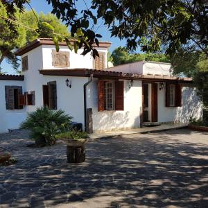 una casa blanca con un patio frente a ella en Villa GREG stupenda location sulla spiaggia con accesso diretto al mare en Terracina