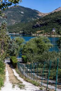 a dirt road with a fence next to a lake at La casetta al lago in Scanno