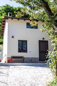 a white building with two windows and a bench at La casetta al lago in Scanno