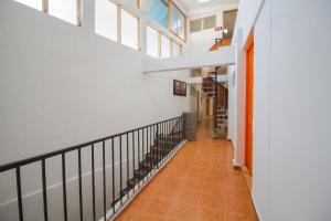 a hallway with white walls and orange tile floors at Hotel San Carlos in Acapulco