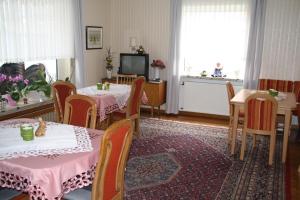 ein Esszimmer mit 2 Tischen und einem TV in der Unterkunft Weinfelderhof in Kröv