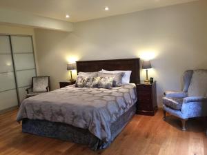 una camera con letto, sedia e lampade di White Lodge B&B a Cooksbridge