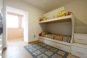 カヴァレーゼにあるAppartamento Dianaの子供用ベッドルーム(二段ベッド1台、ラグ付)