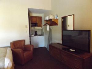 ein Hotelzimmer mit einem TV und einem Stuhl in der Unterkunft Windjammer Lodge in Ogdensburg