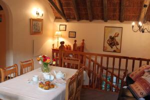 a dining room with a table with food on it at Plotsklaps Self Catering Cottage in Tokai