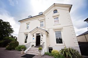 a white house with stairs in front of it at Beaumont House in Cheltenham