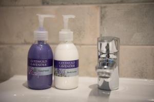 two bottles of soap and a glass on a sink at The Lodge at Broadway in Broadway