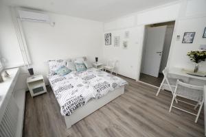 una camera bianca con letto, tavolo e sedie di Apartman Kutak a Banja Luka