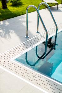 uma piscina com uma escada de metal na água em ALEA - Garda Lake Suite em Arco