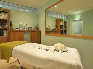 a hospital room with a bed and a mirror at Pestana Palm Gardens in Carvoeiro