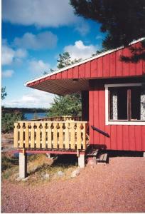 FinströmにあるSöderö Stugbyの白窓と柵の赤い家