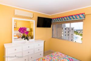 a bedroom with a dresser with a mirror and a window at Turtle Beach Towers in Ocho Rios