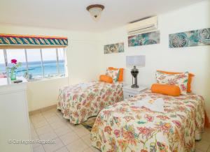 sypialnia z 2 łóżkami i oknem w obiekcie Turtle Beach Towers w mieście Ocho Rios