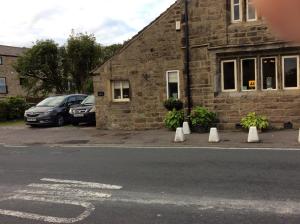 a stone building with cones on the side of a street at Rye Flatt Bed and Breakfast in Colne