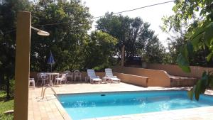 a swimming pool with chairs and a table and a patio at Chácara do Seu Dito in Salto de Pirapora