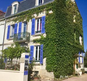 ルーアンにあるGîte chez Madeleineの蔦葺き屋根の家(青い窓、青いシャッター付)