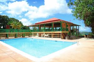 a pool with a gazebo next to a building at Hacienda Juanita in Maricao