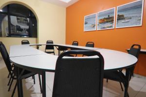 una sala de reuniones con mesas y sillas blancas en Hotel Dom Passos, en Salvador