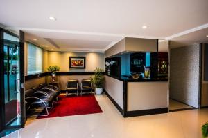 a bar in a hotel with leather chairs and a red rug at Cllin Premium Plaza in Muriaé