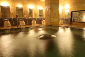 a bath room with a fountain in the middle of it at Tsuruya Ryokan in Karuizawa