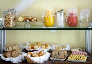 a shelf filled with different types of bread and juice at Pousada Cantagalo in Itaipava