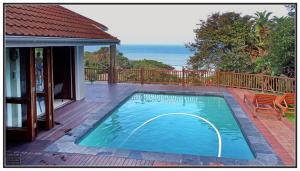 une piscine sur une terrasse à côté d'une maison dans l'établissement Peace Cottage, à Port Shepstone