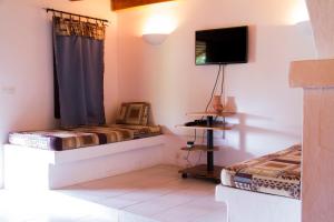 a room with two beds and a flat screen tv at African Queen Lodge in Assinie