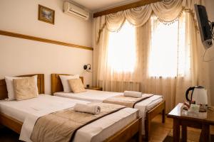 2 Betten in einem Zimmer mit Fenster in der Unterkunft Bed and Breakfast Vijecnica in Sarajevo