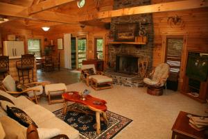 a living room with a stone fireplace in a cabin at Silver Ridge Resort in Eureka Springs