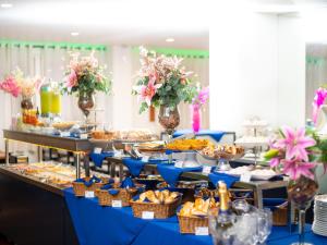 a buffet of food on a blue table at Hotel Normandie in Sao Paulo