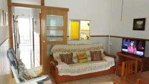 a living room with a couch and a tv at Viviendas Moreno Mar Menor in Santiago de la Ribera