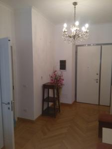 Zimmer mit einem Kronleuchter und einem Tisch mit Blumen in der Unterkunft Orchidea - Sanremo Apartments in Sanremo