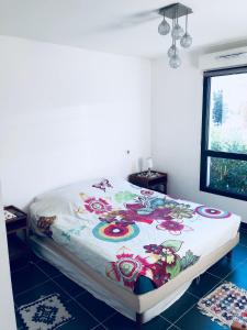 a bed with a colorful blanket on it in a room at Appartement 1 ROYAL VILLEROY in Sète