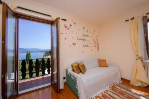 1 dormitorio con cama y ventana grande en The Cottage on the Lake, en Baveno