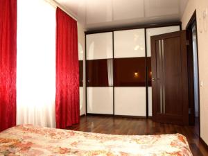 - une chambre avec un lit et un rideau rouge dans l'établissement Апартаменты с балконом, à Kharkov