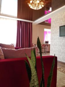a living room with a red couch and a plant at Апартаменты с балконом in Kharkiv