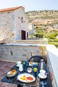 a table with plates of food on a balcony at Limeni Inn Boutique Hotel Adults only 12plus in Limeni