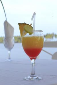 a drink in a glass with a lime on a table at African Queen Lodge in Assinie