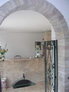 a kitchen with a brick wall and an archway with a door at Hotel La Quiete in Assisi