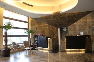 a lobby with a flat screen tv and chairs at Hotel International Prishtina & Spa in Pristina +55 photos